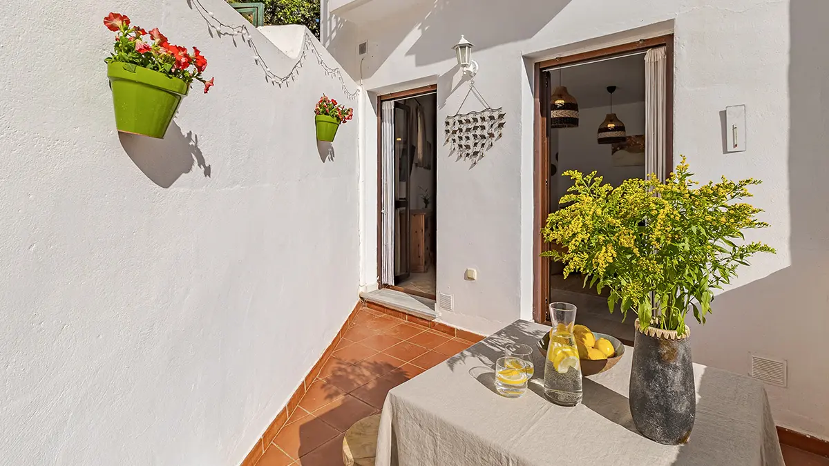 Whitewashed entrance patio with plants – apartment for sale in Frigiliana
