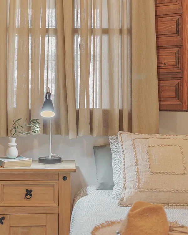 Bedroom corner with linen curtains and bedside lamp – apartment in Frigiliana